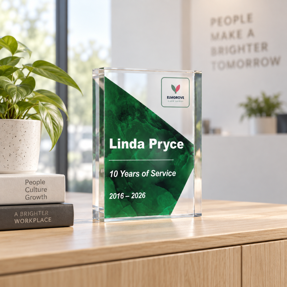 Personalised long service award in forest green printed 10 Years of Service, a clear acrylic staff award on a desk