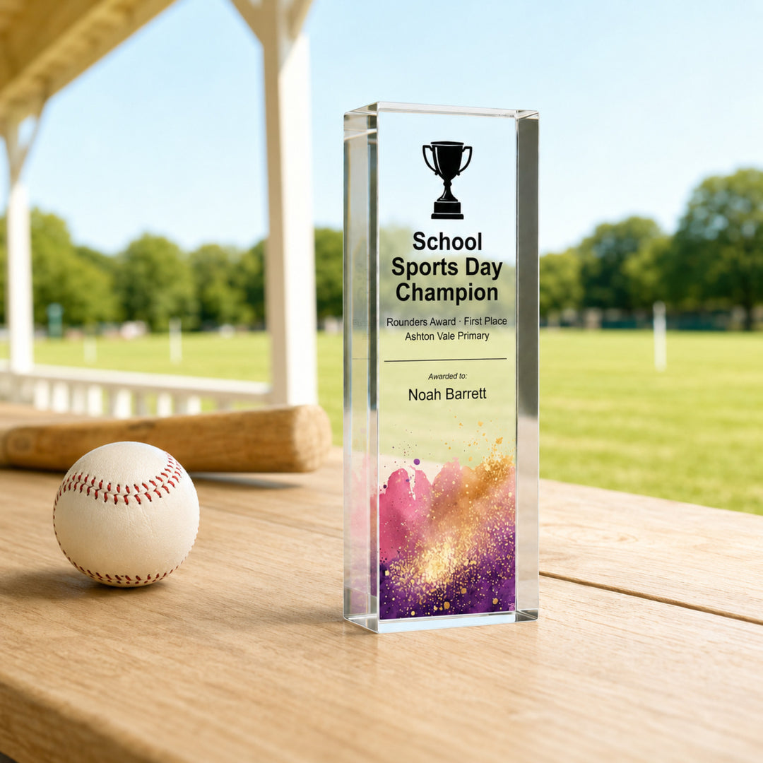 Slim upright personalised rounders trophy printed School Sports Day Champion beside a ball
