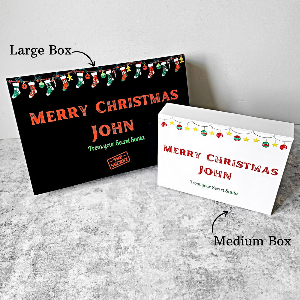 Two Christmas gift festive gift boxes, one large and one medium, on a gray surface.