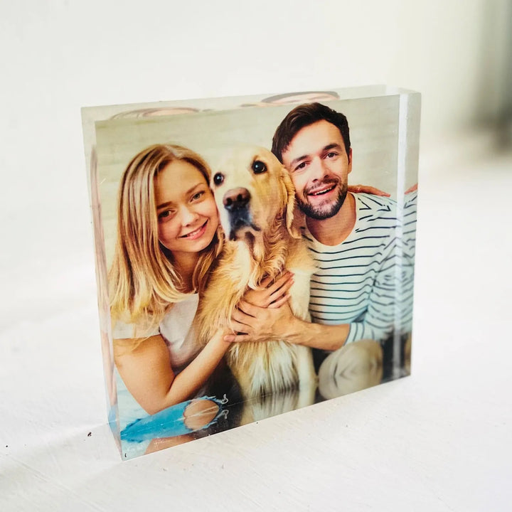 Acrylic photo block with a photo of a couple and their dog on a white surface