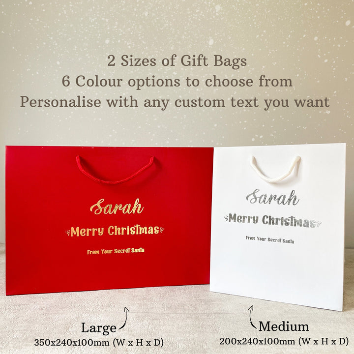 Two personalized Secret Santa gift bags in red and white with custom text. The large bag measures 350x240x100mm and the medium bag measures 200x240x100mm. Both bags feature the name "Sarah" and the message "Merry Christmas" along with "From Your Secret Santa."